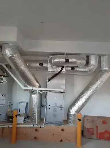 Insulated metal HVAC ducts with air handler unit and yellow support braces installed