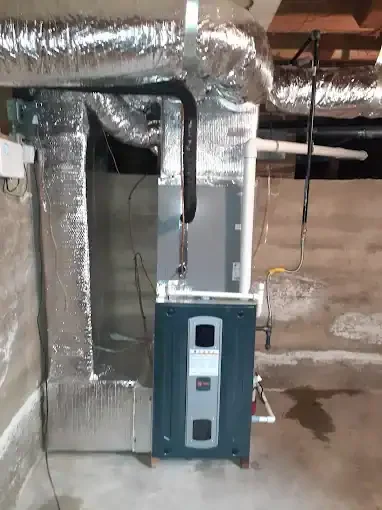 Basement HVAC furnace unit with insulated ductwork and digital thermostat controls